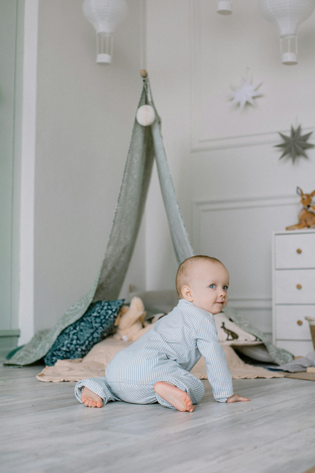 Neutral nursery decor featuring a baby crawling on the floor in a calm minimalist baby room with soft textures, muted tones, and cozy modern nursery styling.