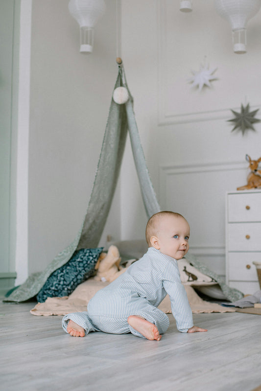 Neutral nursery decor featuring a baby crawling on the floor in a calm minimalist baby room with soft textures, muted tones, and cozy modern nursery styling.