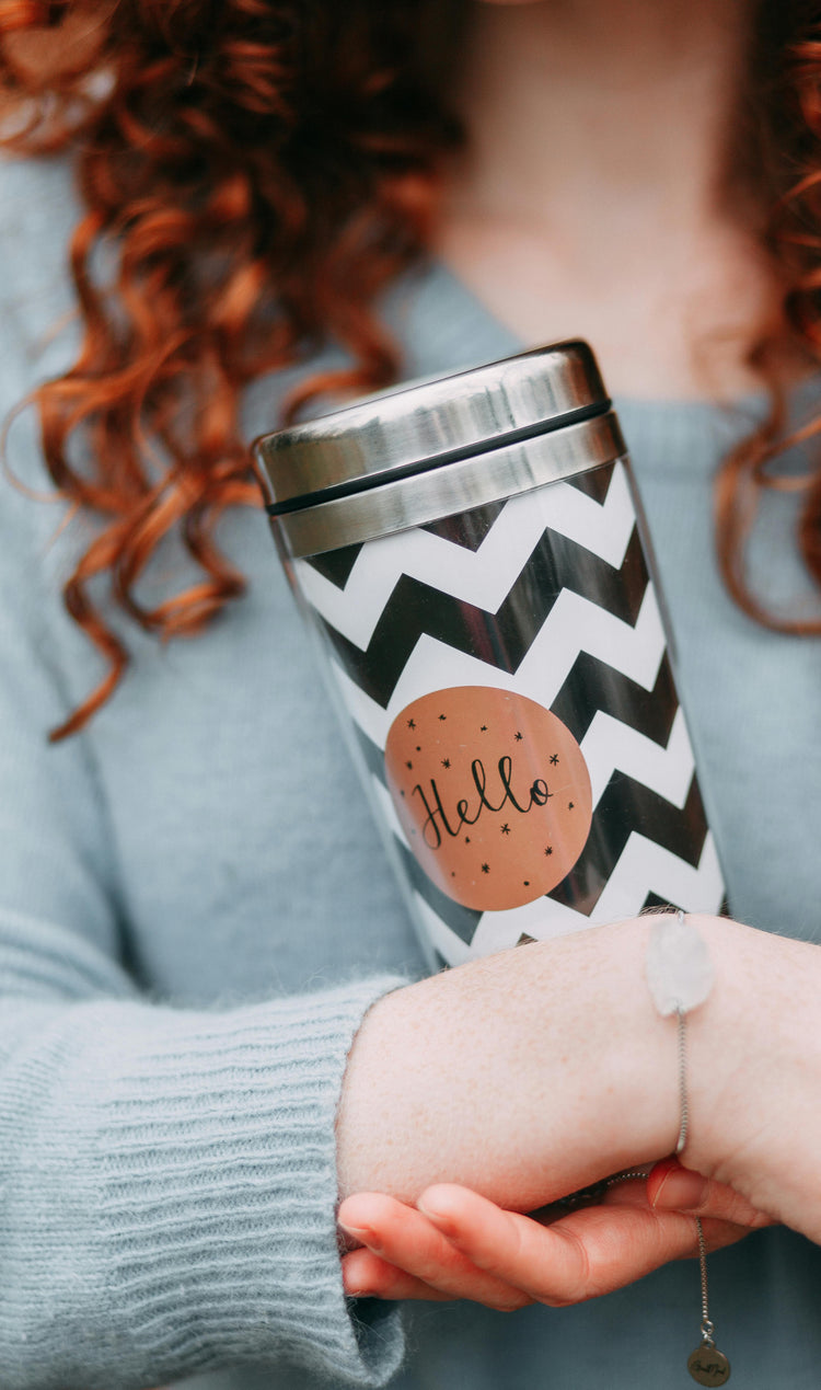 woman holding stainless steel tumbler with black and white chevron design — modern reusable coffee cup uk homeware